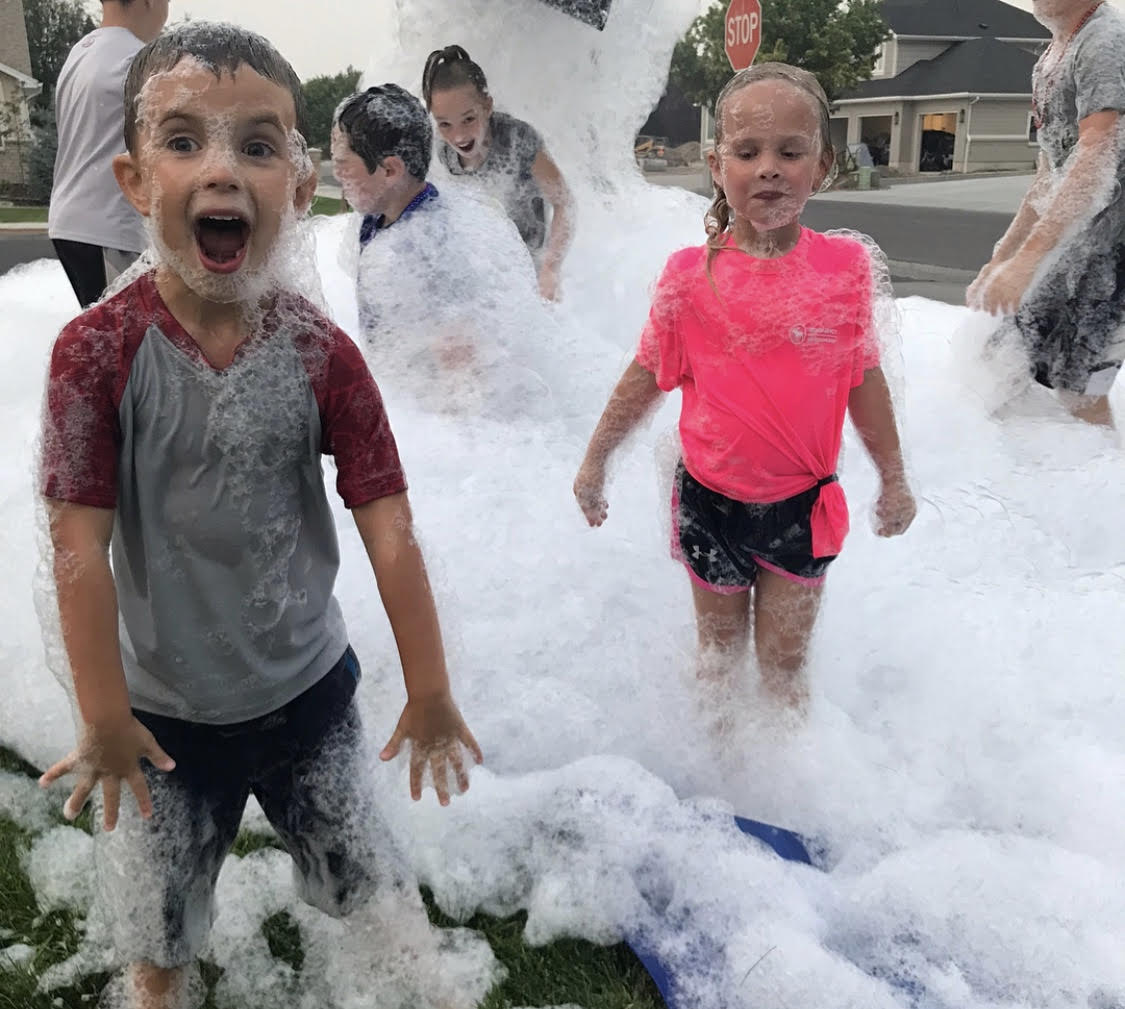 Children laughing together at a neighborhood foam party