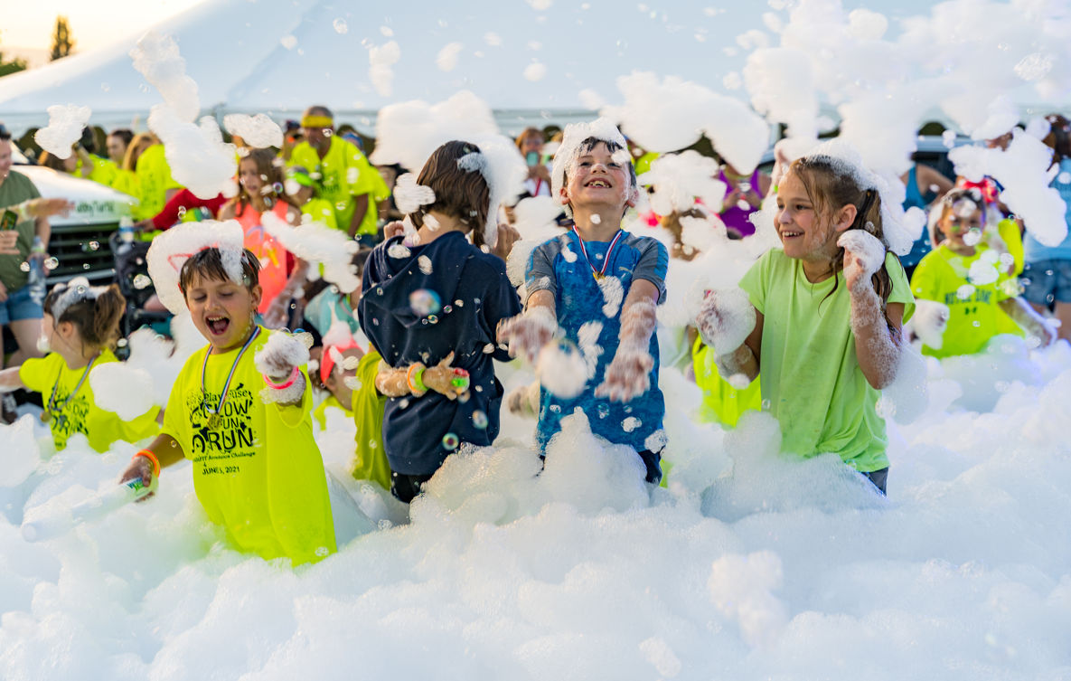 A large group of children enjoying a community foam event